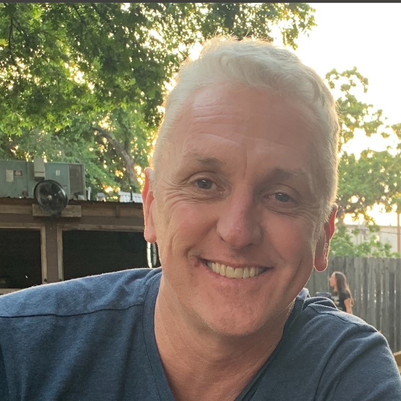 Smiling host of Taste of Austin Tours outdoors at golden hour